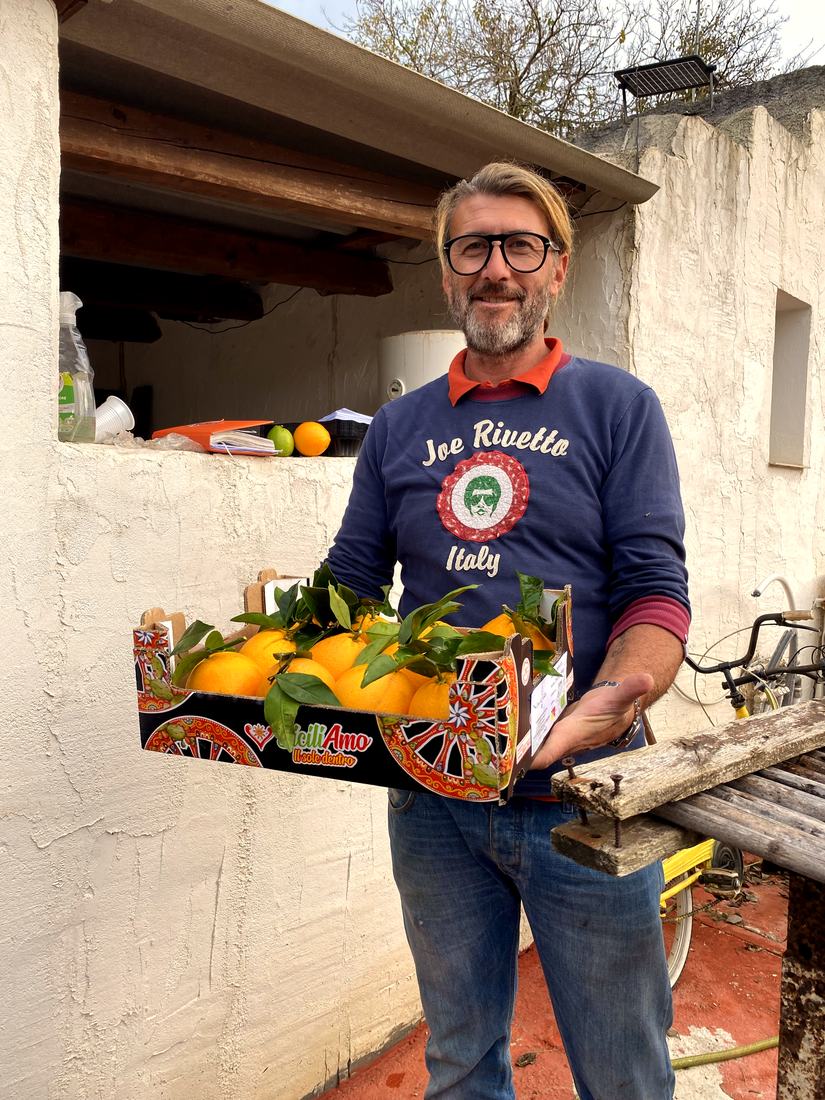 Emilio auf der Casa del Gelso mit einer frisch gepflückten Kiste Orangen